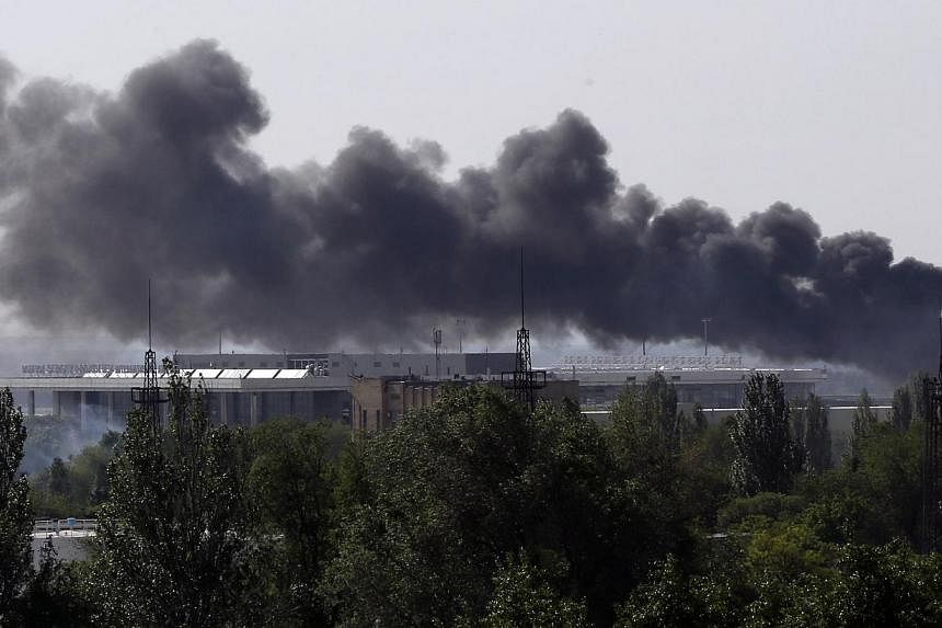 Smoke billows from Donetsk international airport during heavy fighting between Ukrainian and pro-Russian forces on May 26, 2014.&nbsp;European security watchdog OSCE said on Tuesday it had lost contact with one of its teams of monitors near the town 