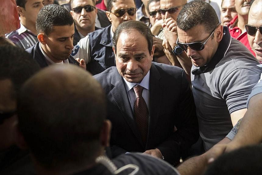 Egypt's former army chief and leading presidential candidate Abdel Fattah al-Sisi (centre) arriving at a polling station in Heliopolis, Cairo, yesterday to vote.