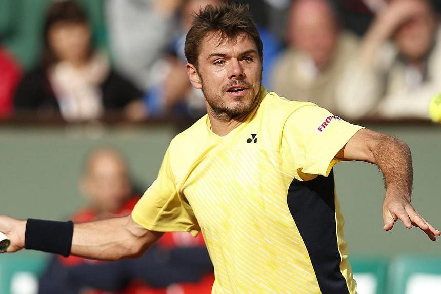 Stan Wawrinka of Switzerland returns to Guillermo Garcia-Lopez of Spain during their first round match for the French Open tennis tournament at Roland Garros in Paris, France on May 26, 2014. -- PHOTO: EPA