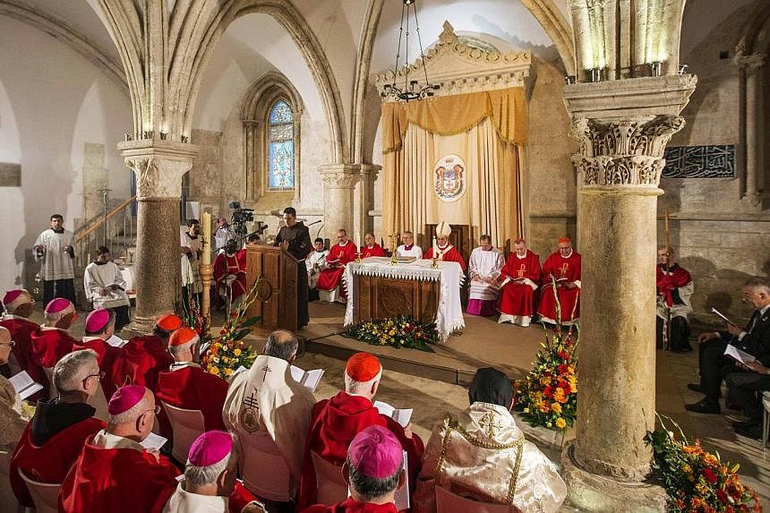 Clergymen attend a mass celebrated by Pope Francis (rear centre) at the Cenacle, where Christian tradition says Jesus attended The Last Supper, on Mount Zion just outside Jerusalem's Old City on May 26, 2014. -- PHOTO: REUTERS