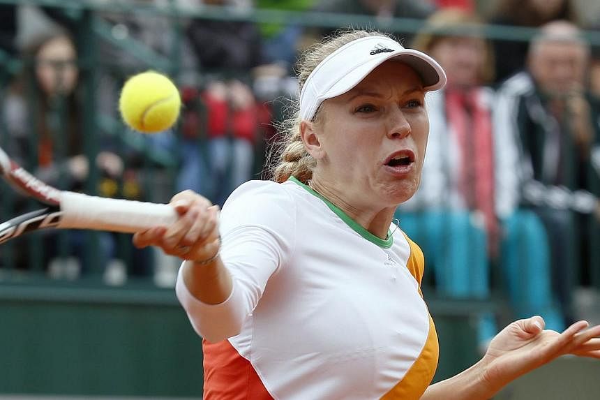 Denmark's Caroline Wozniacki returns the ball to Belgium's Yanina Wickmayer during their French tennis Open first round match at the Roland Garros stadium in Paris on May 27, 2014. -- PHOTO: AFP