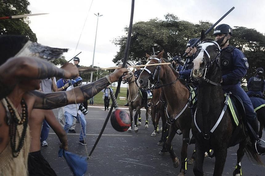 Police confront native Brazilians to impede them from marching towards the Mane Garrincha football stadium during a demonstration in Brasilia, May 27, 2014. -- PHOTO: REUTERS