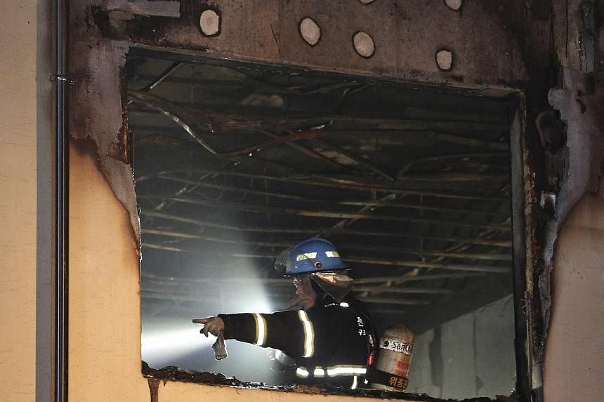 A firefighter works at the scene of a fire at a hospital in Jangseong, south-west region of Jeolla on May 28, 2014. -- PHOTO: REUTERS&nbsp;
