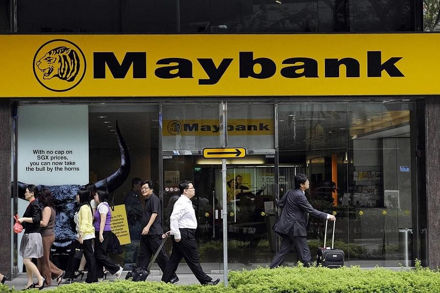 Pedestrians walk past a Maybank branch in Singapore.&nbsp;Maybank Singapore posted strong first quarter results with a 10.5 per cent rise in pre-tax profit to $110.9 million on the back of a 12.2 per cent rise in net income. -- PHOTO: BLOOMBERG