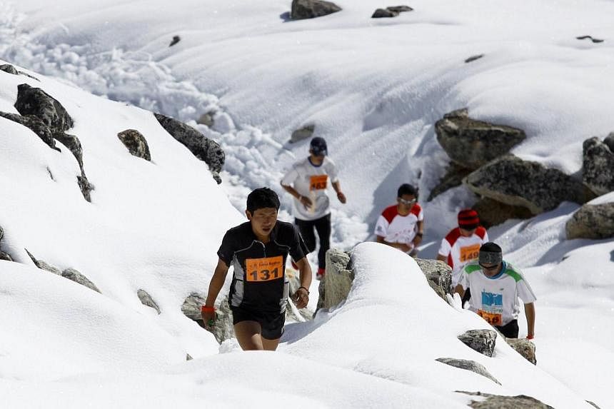 In this photograph received by Himex, the organisers of the Tenzing-Hillary Everest Marathon on May 29, 2014, marathon participant Sudip Kulung (left) takes part in the event near Gorapshep at Mount Everest Base camp in Nepal. -- PHOTO: AFP/HIMEX