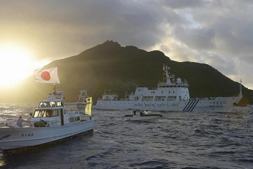 Chinese marine surveillance ship Haijian No. 51 (centre) sails near Japan Coast Guard vessels (right and left) and a Japanese fishing boat (front 2nd left) as Uotsuri island, one of the disputed islands, called Senkaku in Japan and Diaoyu in China, i