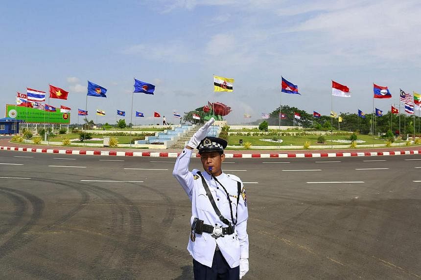 A traffic policeman standing before country flags at the 24th Asean summit in Naypyidaw on May 10. The year 2015 will mark a major turning point in the region's history. South-east Asians need to re-learn the lesson of the earlier generation of natio