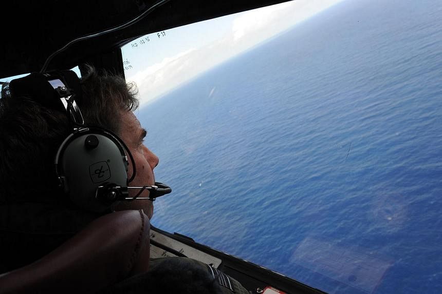 Royal New Zealand Airforce P-3K2-Orion aircraft co-pilot Brett McKenzie helps to look for objects during the search for missing Malaysia Airlines flight MH370, off Perth on April 13, 2014. -- PHOTO: AFP&nbsp;