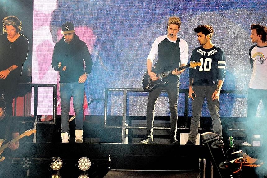 British Group One Direction perform in concert in Santiago, on April 30, 2014. Louis Tomlinson of British pop phenomenon One Direction has apparently filmed himself smoking what he called a joint, sharing it with bandmate Zayn Malik, in footage circu