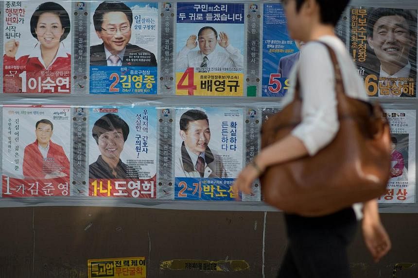 The posters of local election candidates are dispolayed on a wall in Seoul on May 29, 2014. -- PHOTO: AFP&nbsp;