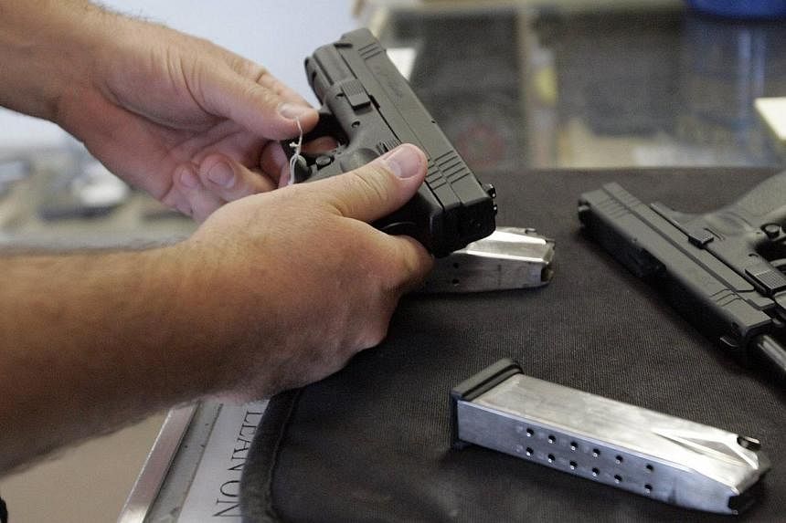 A customer inspects a 9mm handgun at Rink's Gun and Sport in the Chicago, suburb of Lockport, Illinois on June 26, 2008. -- PHOTO: REUTERS