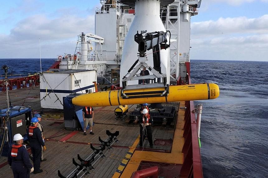 Crew aboard the Australian Defence Vessel Ocean Shield move the US Navy’s Bluefin-21 into position for deployment in the southern Indian Ocean on April 14, 2014, to look for the missing Malaysian Airlines flight MH370 in this picture released by th