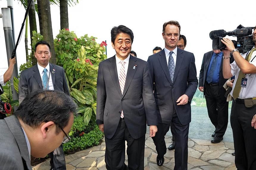 Japanese Prime Minister Shinzo Abe (left) smiles as he walk with George Tanasijevich (right), Marina Bay Sands President and CEO during his visit on the rooftop garden of the Marina Bay Sands on on May 30, 2014 in Singapore.&nbsp;&nbsp;Japanese Prime