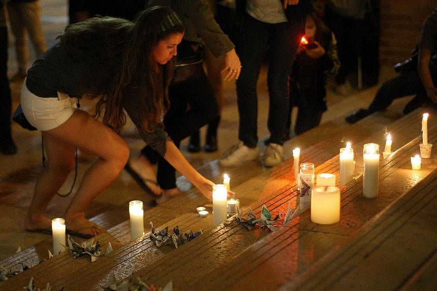 A students places a candle as students of UCSB and UCLA mourn at a candlelight vigil at UCLA for the victims of a killing rampage over the weekend near UCSB on May 26, 2014, in Los Angeles, California.&nbsp;Police officers who visited Elliot Rodger j