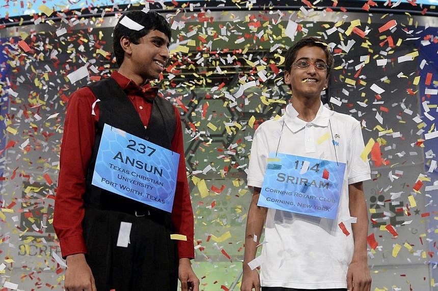 Co-champions of the Scripps National Spelling Bee Ansun Sujoe (left) of Fort Worth, Texas and Sriram Hathwar (right) of Painted Post, New York, stand under falling confetti after winning, at National Harbor, Maryland, USA, on May 29, 2014. -- PHOTO: 