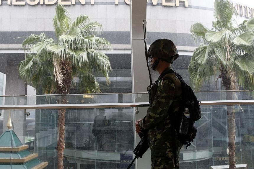 A soldier stands guard at an elevated walkway of a shopping district in central Bangkok on May 25, 2014. Thailand is expected to publish data on Friday showing stagnant consumption and investment, more evidence of a stumbling economy that will lend u