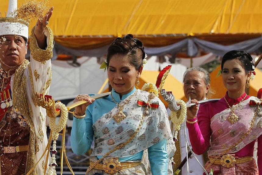 Chavalit Chookajorn (L), permanent secretary of the Thai Ministry of Agriculture and Cooperatives, throws rice grains while dressed in a traditional costume during the annual Royal Ploughing Ceremony, in central Bangkok May 9, 2014. The country's fin