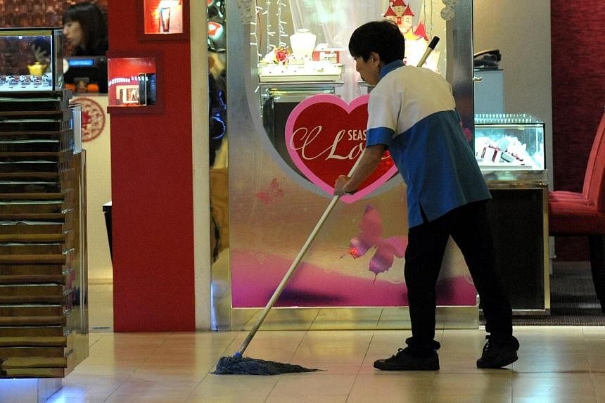 A cleaner mopping the floor in Ang Mo Kio Hub. For the third year in a row, the National Wages Council (NWC) has singled out low-wage workers and recommended they receive a minimum amount of pay increase.&nbsp;-- PHOTO: ST FILE