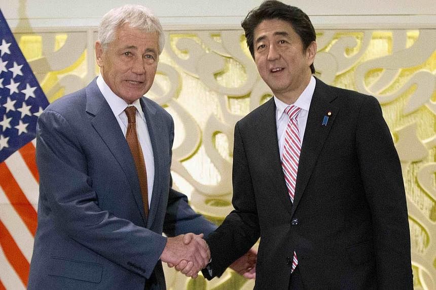 US Defense Secretary Chuck Hagel (left) shakes hands with Japanese Prime Minister Shinzo Abe at the start of their meeting in Singapore, on May 30, 2014. -- PHOTO: REUTERS