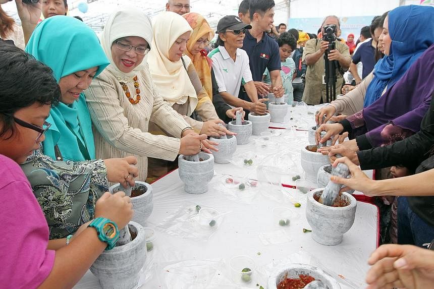 Speaker of Parliament Halimah Yacob (third from left) at a community carnival to celebrate the 25th anniversary of Muhammadiyah Welfare Home.&nbsp;A hundred people got into the Singapore Book of Records on Saturday for being the "most number of peopl