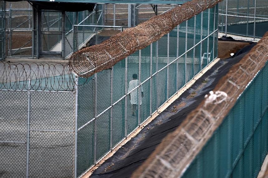 This photo made during an escorted visit and reviewed by the US military shows an unidentified detainee walking at the excercise yard at "Camp 6" detention facility at the US Naval Station in Guantanamo Bay, Cuba, in this April 08, 2014, file photo. 