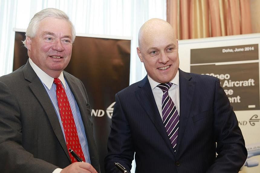 Airbus chief operating officer John Leahy (left) and Air New Zealand chief executive Chistopher Luxon pose in front of a scale model of a A320neo during a news conference in Doha on June 1, 2014. Air New Zealand said on Sunday that it has placed an o