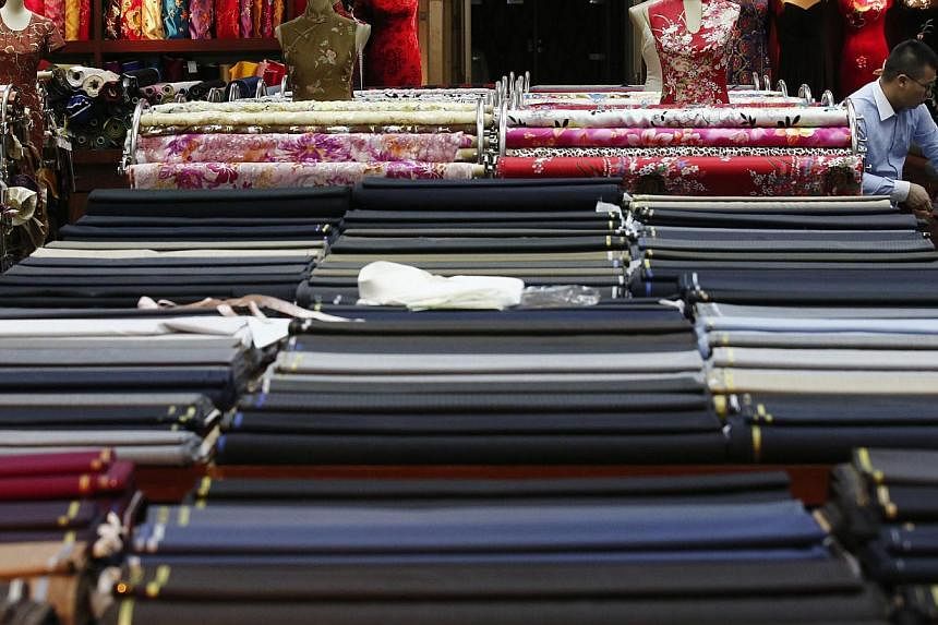 An employee works in a clothing shop in Beijing on May 13, 2014. China's factory activity expanded at the fastest pace in five months in May due to rising new orders, official data showed on June 1. -- PHOTO: REUTERS