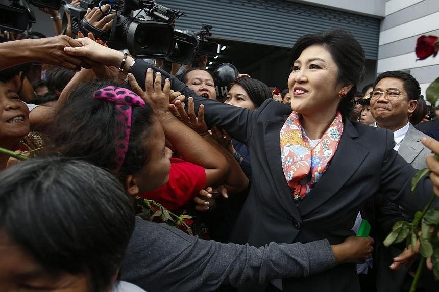 Thailand's Prime Minister Yingluck Shinawatra greets her supporters as she leaves the Permanent Secretary of Defence office in Bangkok on May 7, 2014.Thailand's former Prime Minister Yingluck Shinawatra on Sunday expressed her gratitude to supporters