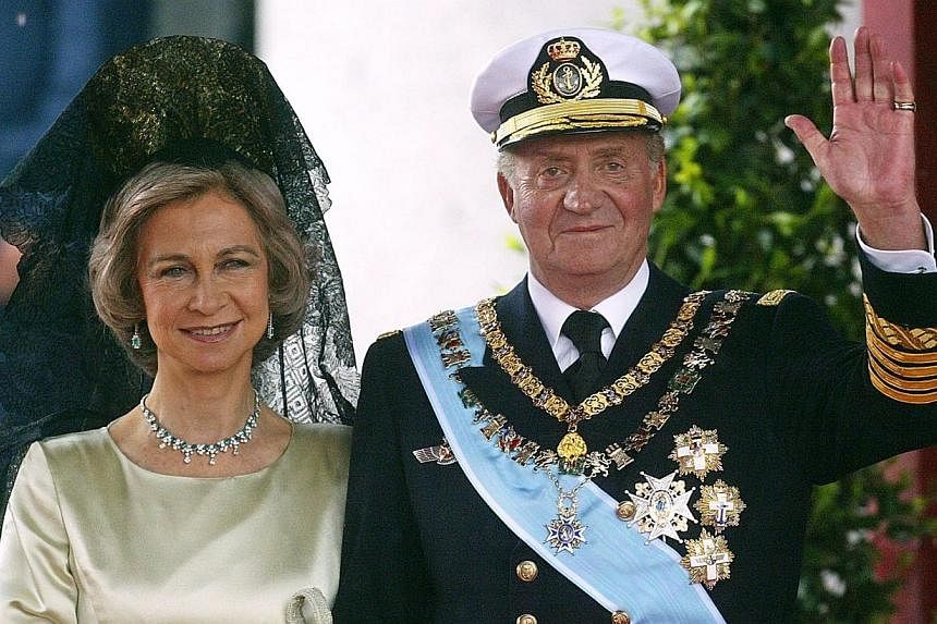 King Juan Carlos of Spain waving to photographers next to his wife Queen Sofia as they leave Madrid's Almudena Cathedral at the end of the wedding of Spanish Crown Prince Felipe and former journalist Letizia Ortiz on May 22, 2004.&nbsp;Spain's King J