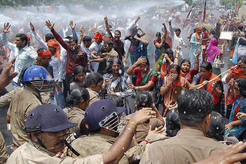 Supporters of Bharatiya Janata Party (BJP) shout slogans as police use a water cannon to stop them from moving towards the office of Akhilesh Yadav, the chief minister of the northern Indian state of Uttar Pradesh, during a protest against recent rap