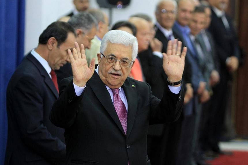 Palestinian president Mahmud Abbas (centre) waves during the swearing-in ceremony of the new Palestinian unity government in the West Bank city of Ramallah on June 2, 2014.&nbsp;Palestinian president Mahmud Abbas hailed the "end" of Palestinian divis