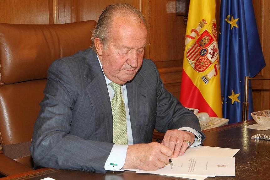 Spain's King Juan Carlos signs his abdication at the Zarzuela Palace, on June 2, 2014.&nbsp;-- PHOTO: REUTERS