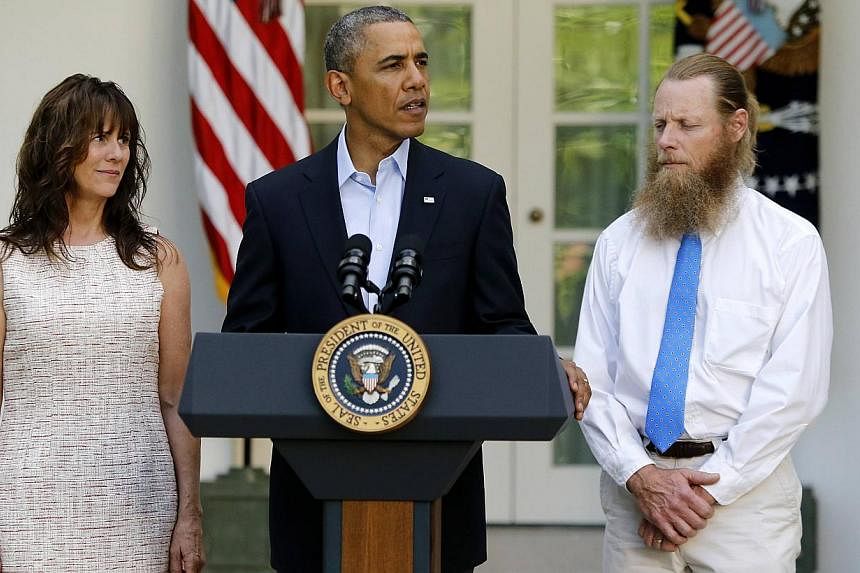 U.S. President Barack Obama stands with Bob Bergdahl (right) and Jami Bergdahl (left) as he delivers a statement about the release of their son, prisoner of war U.S. Army Sergeant Bowe Bergdahl, in the Rose Garden at the White House in Washington on 