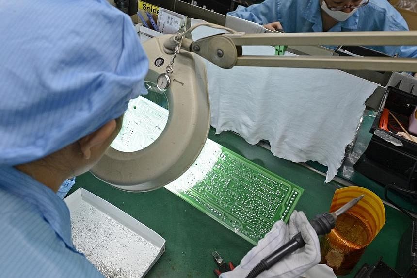 Workers at Add-Plus, an electronics manufacturing company that makes printed circuit boards.&nbsp;Factories seemed to lose&nbsp;some momentum last month after starting the year on a strong footing. -- PHOTO: ST FILE