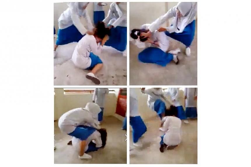 Bad behaviour: Images from the screen grab of the clip showing&nbsp;a schoolgirl being brutally set upon by a group of female schoolmates. -- PHOTO: THE STAR/ASIA NEWS NETWORK