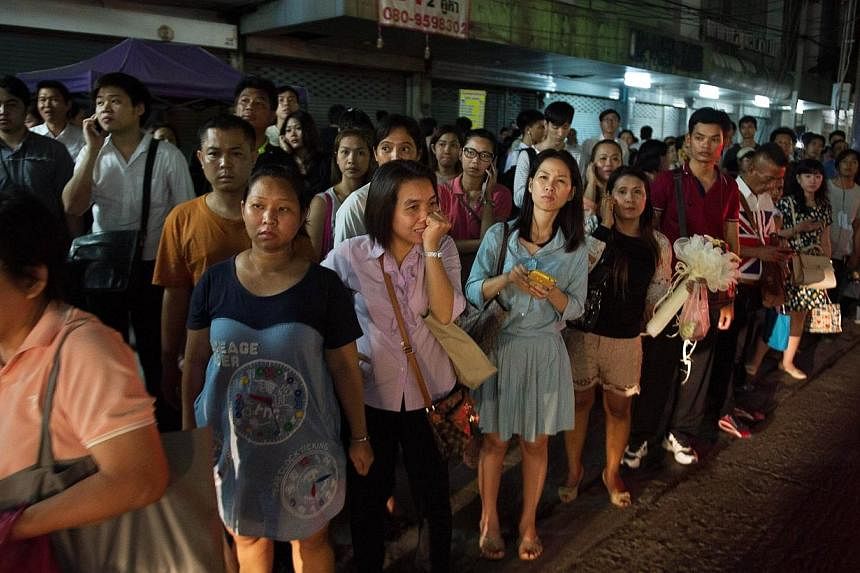 Thai commuters wait for taxis or motorbike taxis as they rush home after a curfew was imposed following the Thai army chief's announcement that armed forces were seizing power in Bangkok on May 22, 2014.&nbsp;Thailand's junta said on Tuesday that it 