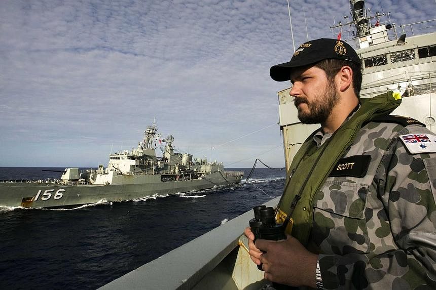 Australian Defence shows Able Seaman Maritime Logistics – Steward Kirk Scott keeping watch on the forecastle of auxiliary oiler HMAS Success as they conduct a Replenishment at Sea with HMAS Toowoomba whilst both ships are deployed in search of the 