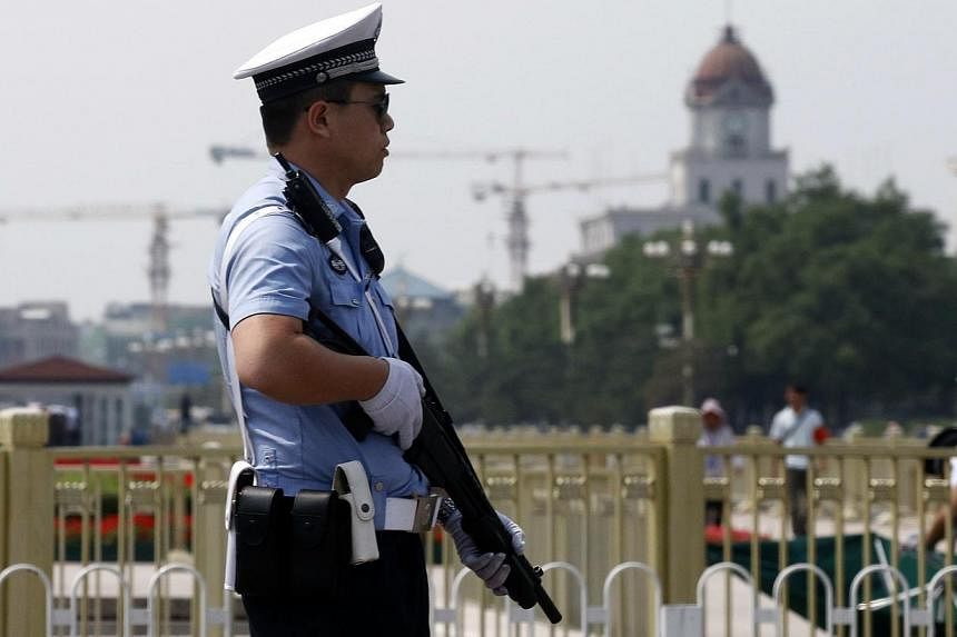 A policeman stands guard with a shotgun in front of Tiananmen Square in Beijing on June 4, 2014. -- PHOTO: REUTERS