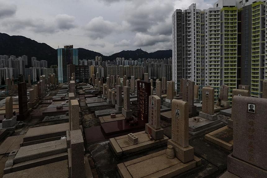 Headstones stand at a cemetery surrounded by residential flats in downtown Hong Kong on May 29, 2014. -- PHOTO: REUTERS