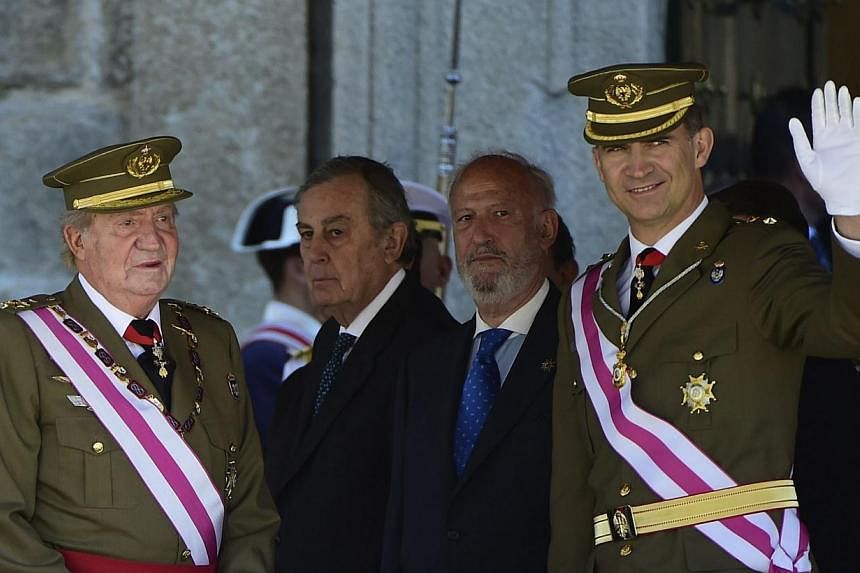 Spanish King Juan Carlos (L) and Spain's Crown Prince Felipe stand during a military ceremony marking the bicentenial of the Royal and Military Order of Saint Hermenegild (Real y Militar Orden de San Hermenegildo) in El Escorial on Jun 3, 2014. Spain