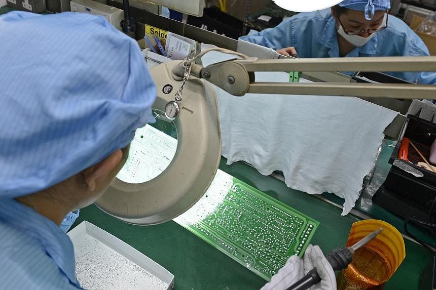 Workers at Add-Plus, an electronics manufacturing company that makes printed circuit boards. Singapore shares eased on Wednesday after a survey showing the city-state's manufacturing activity grew in May but at a slower pace than in the previous mont