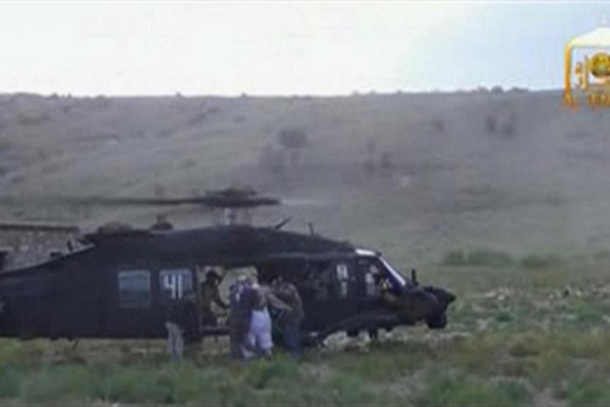 U.S. Army Sergeant Bowe Bergdahl (2nd right, back facing) is led to a waiting Blackhawk helicopter during his release at the Afghan border, in this still image from video released on June 4, 2014. -- PHOTO: REUTERS