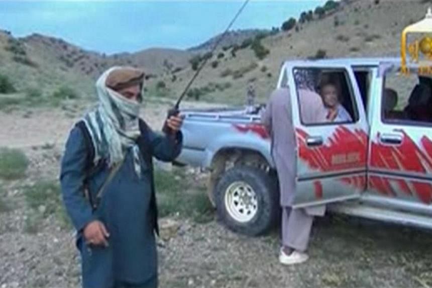 A Taliban militant speaks to U.S. Army Sergeant Bowe Bergdahl (right) waiting in a pick-up truck before his release at the Afghan border, in this still image from video released on June 4, 2014. &nbsp;US President Barack Obama on Thursday, June 5, 20
