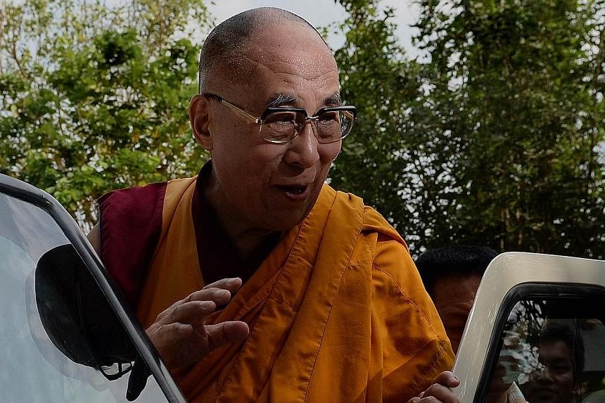 The Dalai Lama waves to followers as he arrives to give a discourse on "Introductory Teaching on Buddhism" in Mumbai on on May 30, 2014. -- PHOTO: AFP