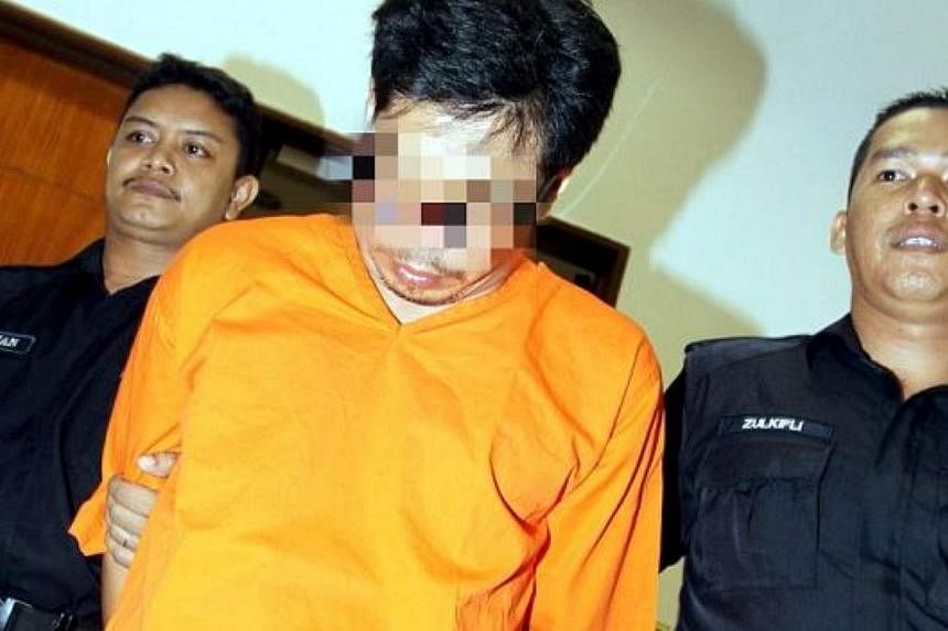 The suspect who led police to the body of an infant being led away by police. The man, in his 40s, has allegedly been sexually abusing at least 29 maids working for him and also withholding their salaries. -- PHOTO: THE STAR/ASIA NEWS NETWORK