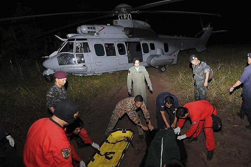 Search and rescue personnel prepare to load a body on to a Royal Malaysian Air Force helicopter during the search for missing British backpacker Gareth Huntley at Juara village on Tioman Island on June 4, 2014. -- PHOTO: REUTERS