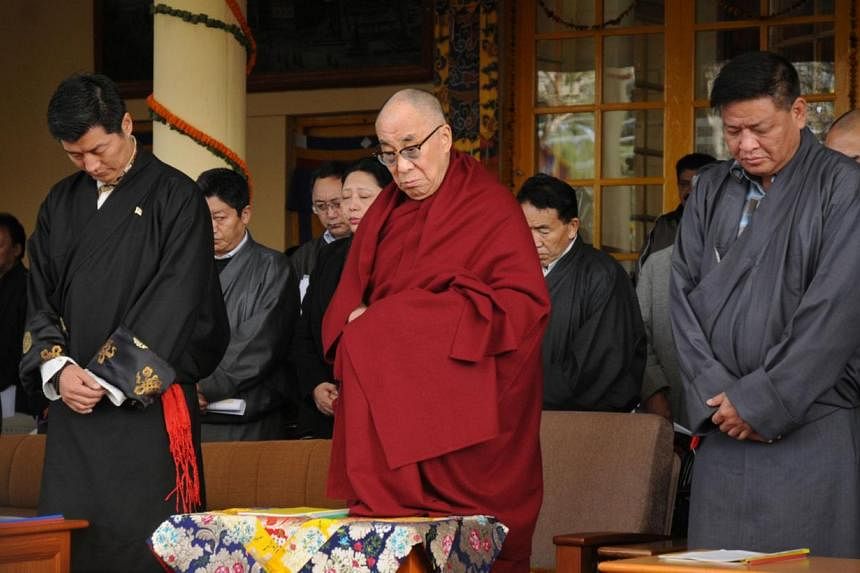 In this photograph taken on Mar 10, 2012, Tibetan spiritual leader the Dalai Lama (C), Kalon Tripa of the Central Tibetan Administration Lobsang Sangay (L), and Speaker of the Tibetan Parliament-in-exile Penpa Tsering (R) observe a minute of silence 