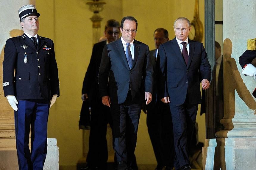 Russian President Vladimir Putin (right), escorted by French President Francois Hollande, leaves the Elysee palace following their meeting and dinner in Paris on June 5, 2014. Russian President Vladimir Putin met for talks with French President Franc