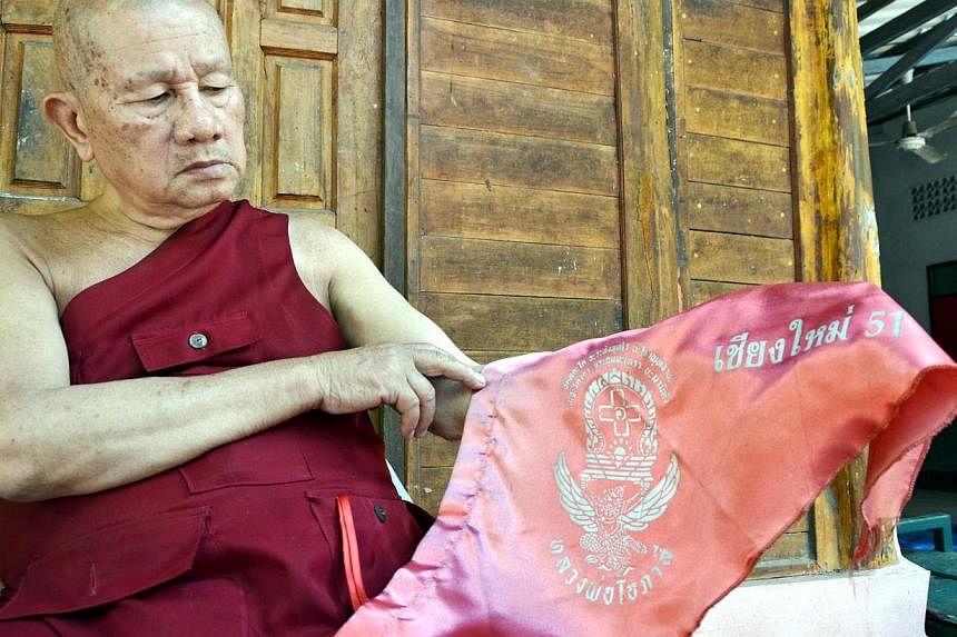 Phra Khru Suthep Sitthikun, the abbot of a temple in Chiang Mai, with the flags that authorities removed from his temple wall because they deemed it a symbol of the red shirts. The red shirts are key supporters of the ousted government. -- ST PHOTO: 