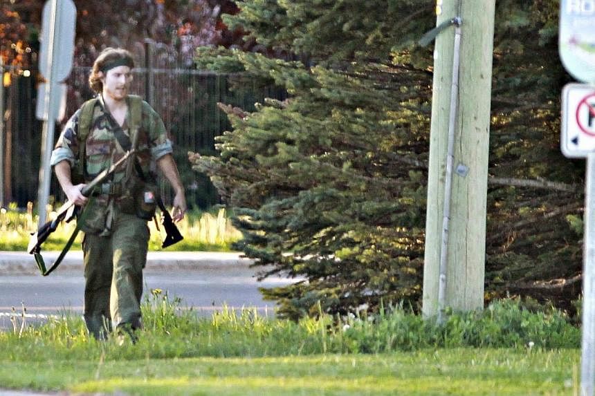 A heavily armed man that police have identified as Justin Bourque walks on Hildegard Drive in Moncton, New Brunswick on June 4, 2014 after several shots were fired in the area.&nbsp;Canadian police said on Friday, June 6, 2014, they had arrested the 